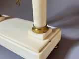 an antique white marble table with a gold lion head on the top