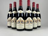 six bouteilles de vin rouge sont alignées sur une table