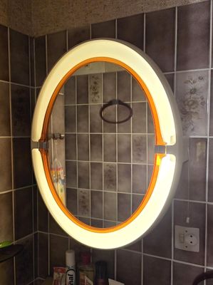 a round mirror on the wall in a bathroom