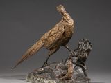 an antique bronze sculpture of a bird on a rock with a mouse