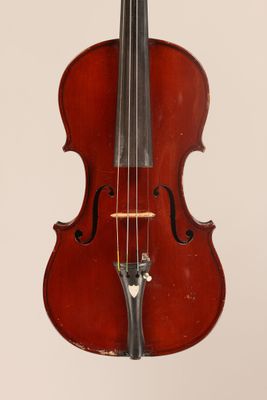 un vieux violon posé sur une table près d'un mur blanc