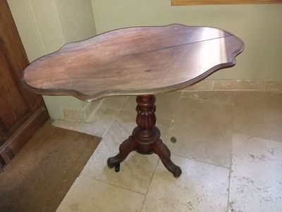 a small table with a wooden top on a tile floor
