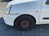 une voiture blanche avec un pneu crevé et une bosse