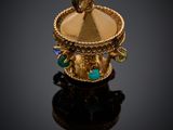 Gros plan sur une bague en or ornée d'une pierre verte