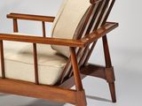 a brown wooden chair with beige cushions and a beige cushion