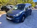 une camionnette bleue garée sur un parking à côté d'une forêt