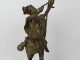 statue en bronze représentant un homme muni d'un bâton et portant un chapeau, sur fond blanc