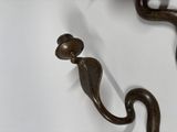a close up of a metal hook with a bird on it