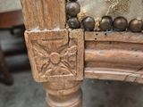 a close up of a wooden chair with beads on it