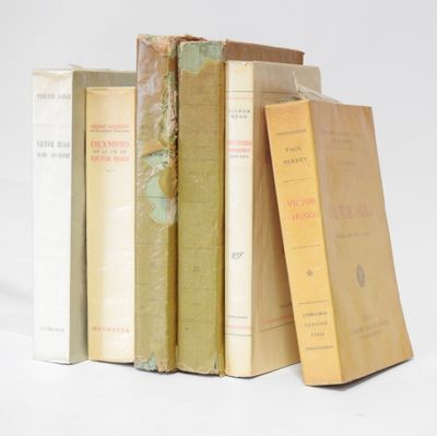 several books are stacked on top of each other on a white surface