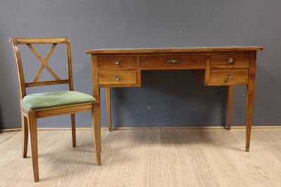 une photo d'un bureau en bois avec une chaise à côté