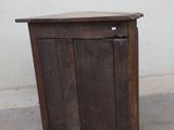 a small wooden cabinet with a door on top of it