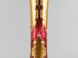un vase en or orné d'un motif rouge