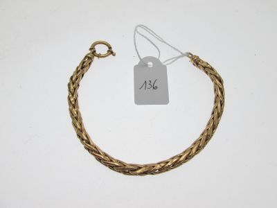 Gros plan sur un bracelet en or portant une étiquette