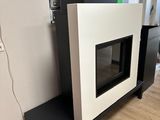 une cheminée noire et blanche dans une pièce avec du parquet