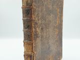 an old book sitting on top of a white surface