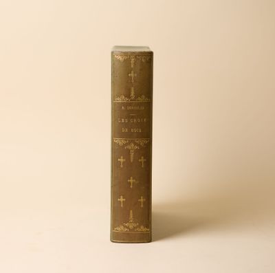 un vieux livre posé sur une table à côté d'un mur blanc