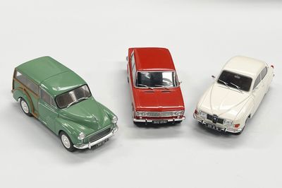 trois petites voitures assises l'une à côté de l'autre sur une surface blanche