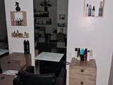 une photo d'un salon de coiffure avec un fauteuil et un miroir