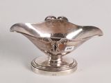 a small silver bowl on a pedestal on a white surface
