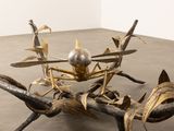 a metal sculpture of a spider on a branch
