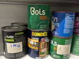 many cans of paint on a shelf in a store