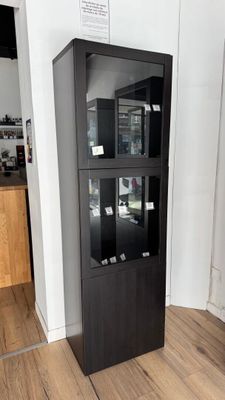 a black cabinet with glass doors in the corner of a room