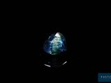 a blue and green sapphire stone on a black surface