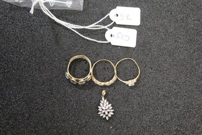 three rings and a necklace on a black surface