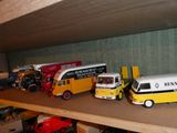 de nombreuses petites voitures et camions sur une étagère dans une pièce
