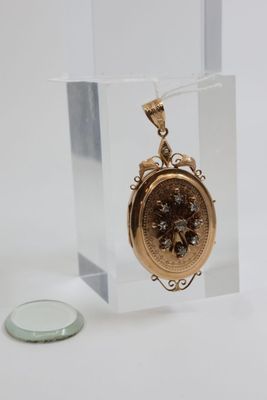 a small gold clock in a glass case next to a coin
