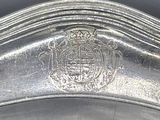 a close up of a silver plate with a crest on it