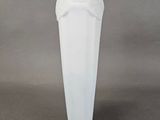 a white vase that has a statue on top of it