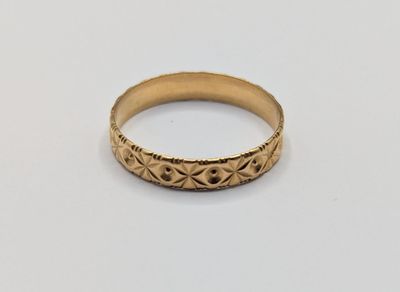 gros plan d'une bague en or sur une surface blanche