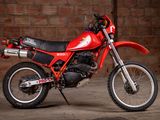 a red dirt bike parked in front of a brick wall