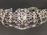 gros plan d'un bracelet en argent sur une surface noire