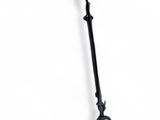 an old iron cross hanging from a chain on a white wall