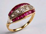gros plan d'une bague en diamant et rubis sur une surface blanche
