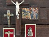 un crucifix posé sur une table en bois, avec des images de Jésus et d'autres objets religieux