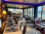 des tables et des chaises dans un restaurant avec vue sur l'eau