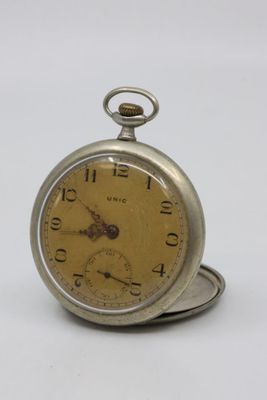 a silver pocket watch sitting on top of a white table