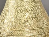 a large gold vase with intricate designs on it