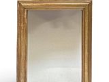 une image d'un miroir encadré d'or sur un fond blanc