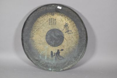 un grand objet métallique orné d'un motif doré et noir