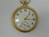a close up of a gold pocket watch on a white surface