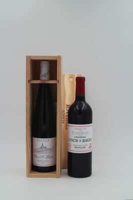 une bouteille de vin dans un coffret en bois à côté d'une bouteille de vin