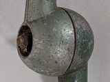 a rusted metal pipe attached to a white wall