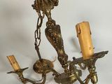 un lustre doré surmonté de deux bougies