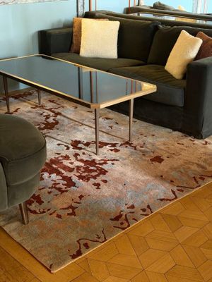 a living room with a couch, chair, coffee table and rug