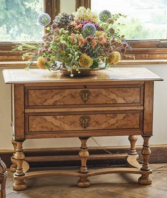 une petite table sur laquelle se trouve un vase de fleurs